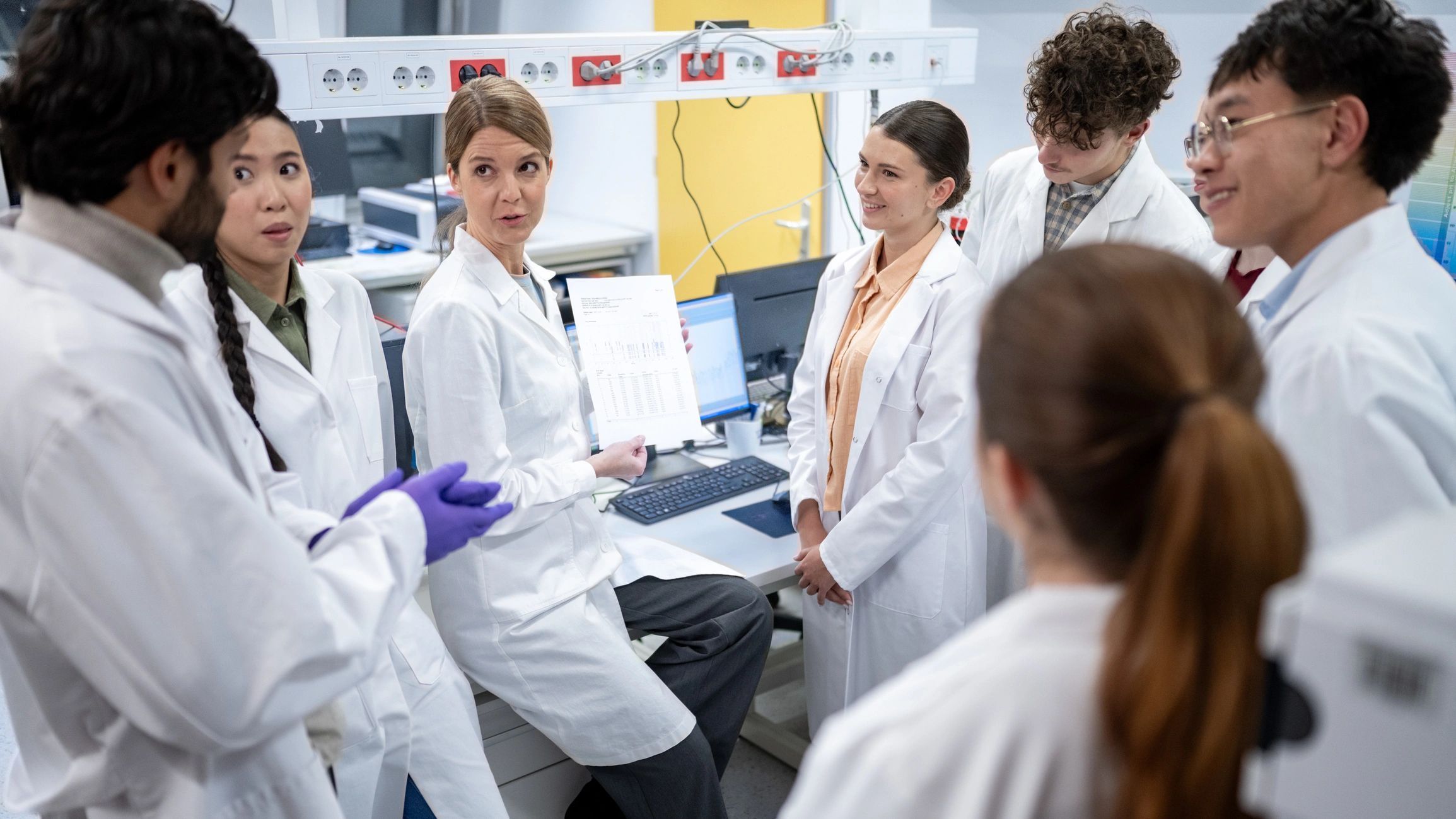Diverse Scientists Discuss Research in Bustling Lab